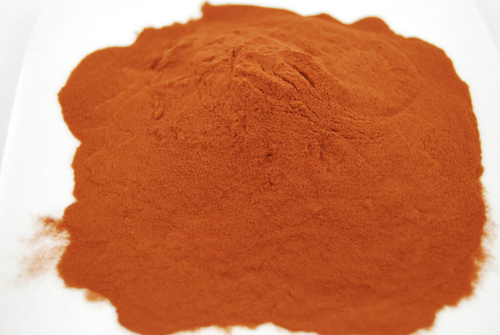 A pile of red powder on top of a white surface.
